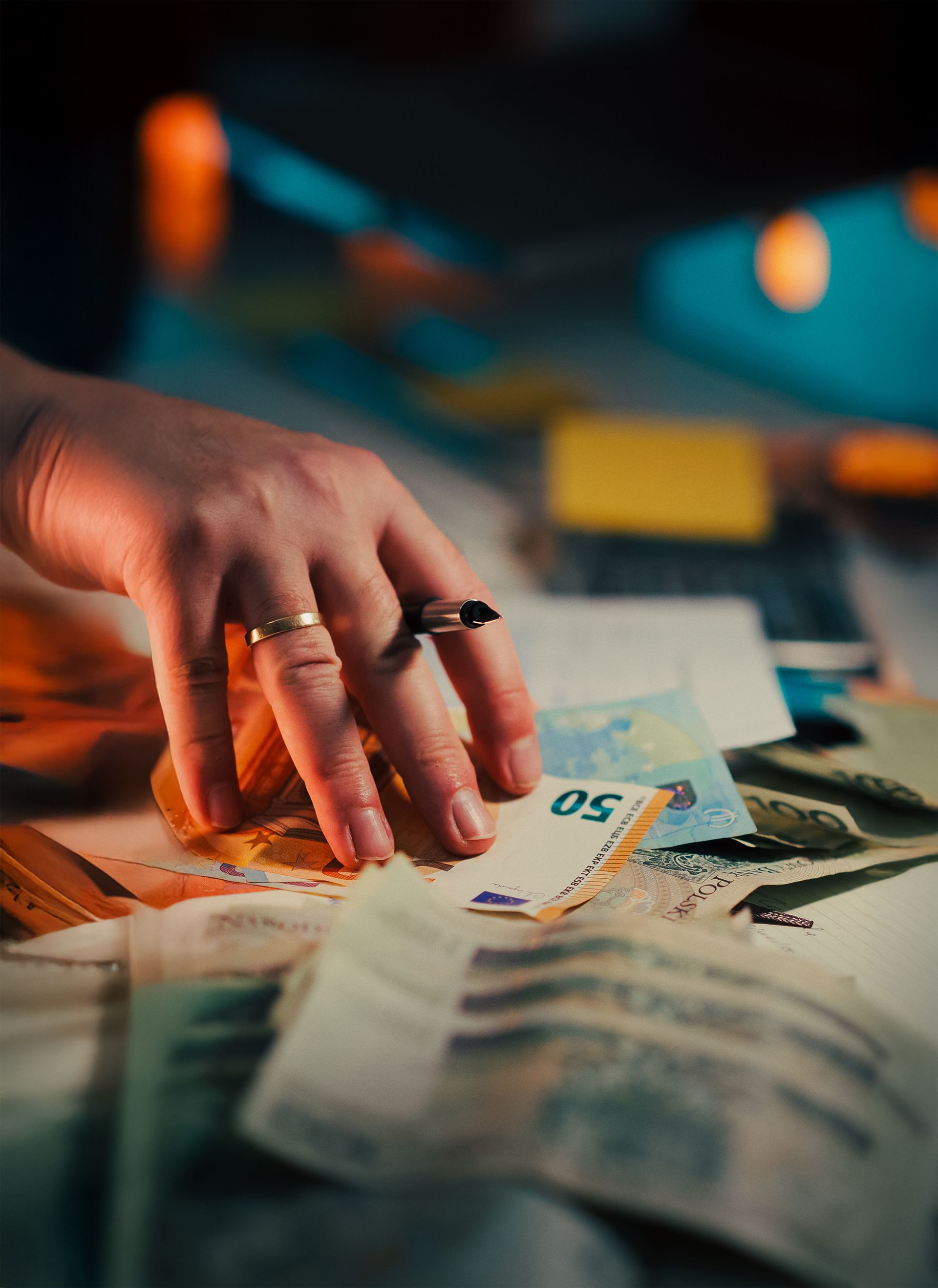 Hand mit Euro-Banknoten und einem Vertrag
